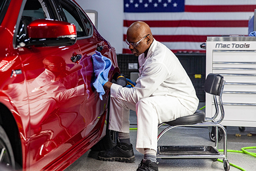 Thợ kiểm tra bề mặt xe.