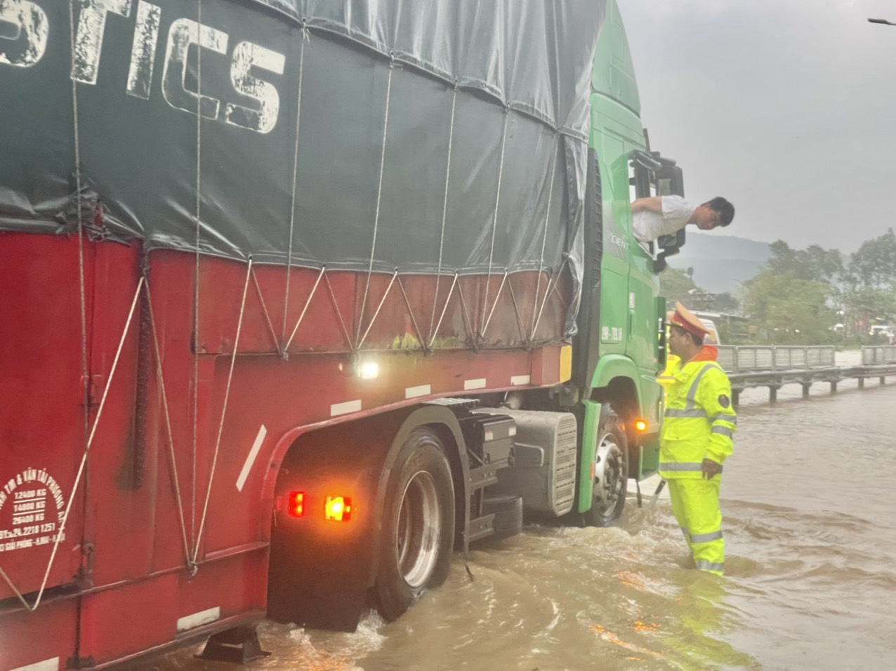 Mưa lớn gây ngập lụt tuyến QL1A qua Huế, CSGT dầm mưa đảm bảo ATGT - Ảnh 1.