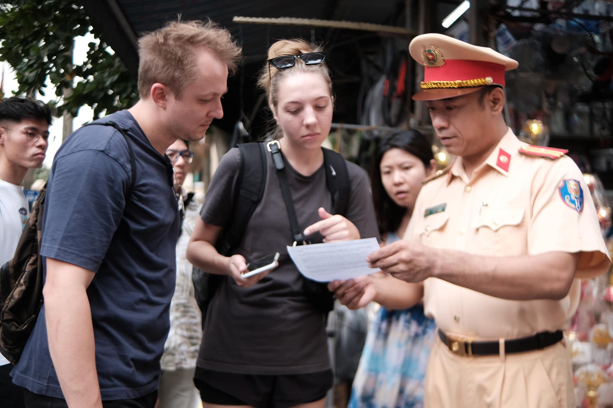 Phát tờ rơi tuyên truyền an toàn đường sắt bằng song ngữ trên "phố đường tàu" - Ảnh 1.