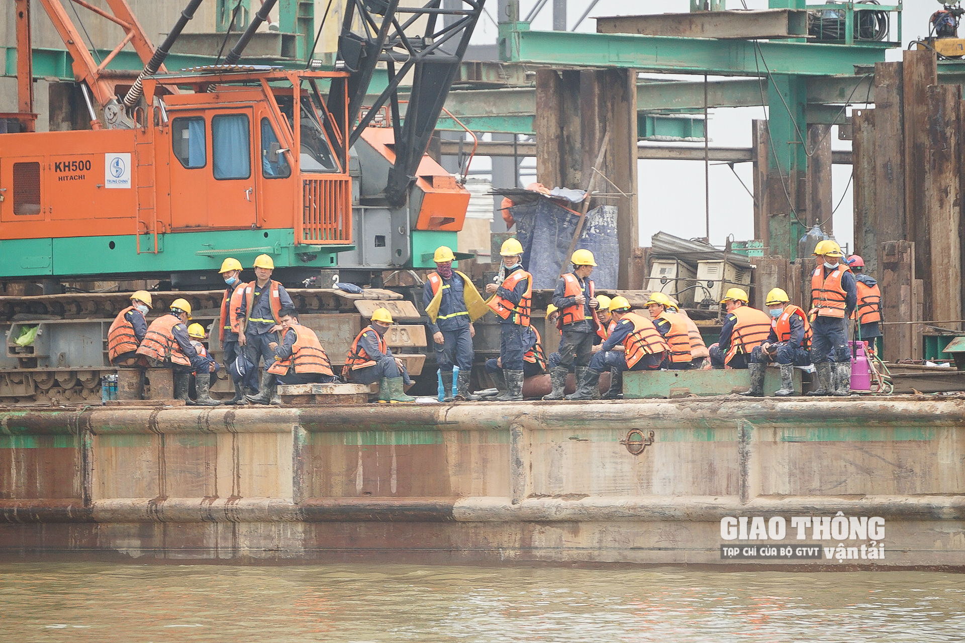 Hàng chục công nhân của nhà thầu Trung Chính vừa hết ca thi công đang đợi ca nô để về ban điều hành ở trong bờ quận Hai Bà Trung