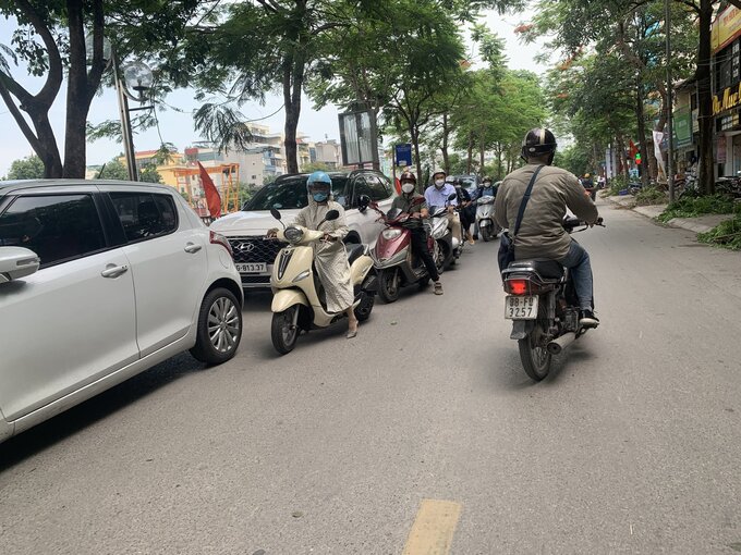 Các phương tiện phải dừng lại, lép mình về phía những chiếc xe đang dừng đỗ chiếm quá nửa chiều rộng làn đường để nhường phương tiện lớn đi chiều ngược lại.