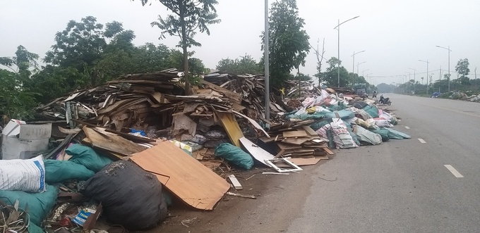 Một bãi rác khổng lồ bịt kín làn đường dành cho xe gắn máy và phương tiện thô sơ