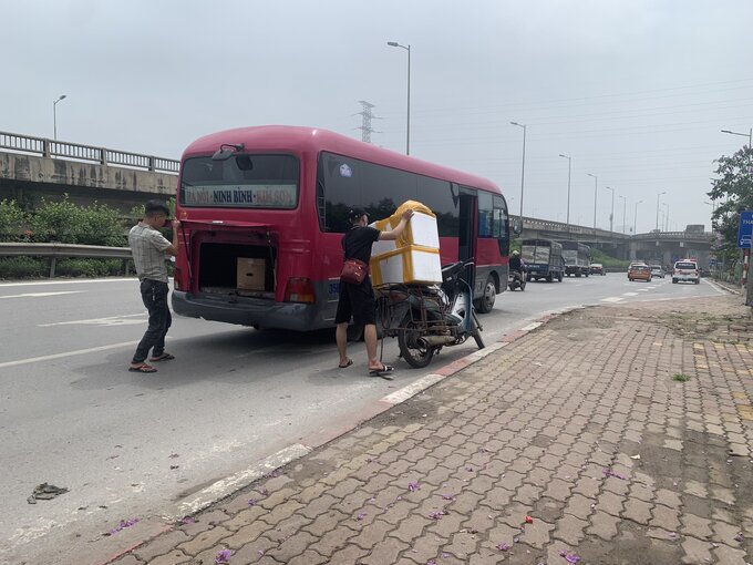 Nhiều shipper đỗ ngay dưới lòng đường để đợi xe khách đến nhận hàng. 