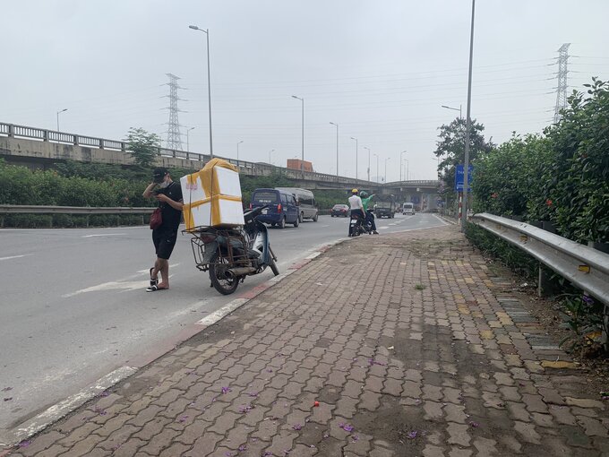 Tài xế xe ôm công nghệ “hướng dẫn” khách bắt xe khách ngay trước lối vào cao tốc. Khu vực các phương tiện lưu thông với tốc độ cao nhưng nhiều người dẫn thảm nhiên dừng đỗ tự do. 