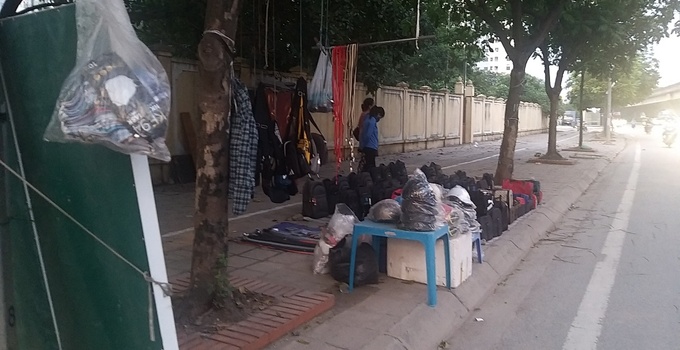 Cách đó không xa, cũng trên đường Nghiêm Xuân Yên, các hàng quán bày bán la liệt túi xách, ba lô, kính râm,... bịt kín lối đi dành cho người đi bộ.