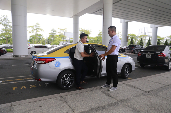 Tài xế của HP NOIBAI TAXI ân cần mở cửa cho khách (ảnh chụp tại sân bay Nội Bài)