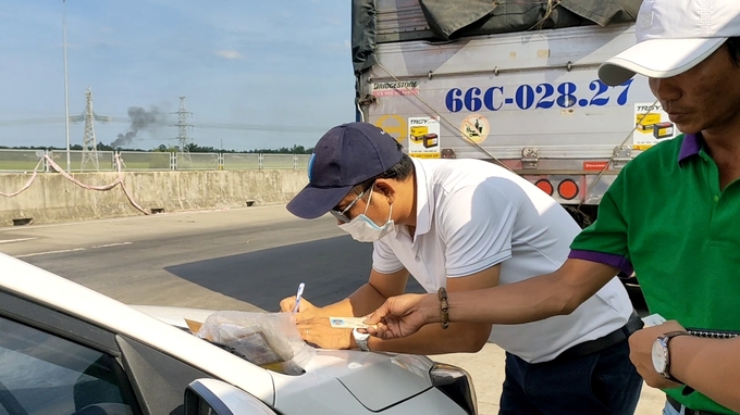 Nhân viên trạm thu phí hướng dẫn tài xế làm tthủ tục đăng ký dịch vụ ETC. 