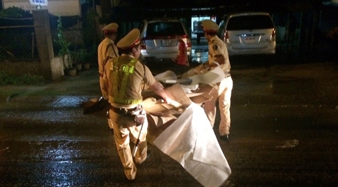 2 CSGT dầm mưa dọn dẹp thùng giấy cát-tô