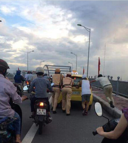 CSGT đẩy xe taxi bị chết máy giúp tài xế