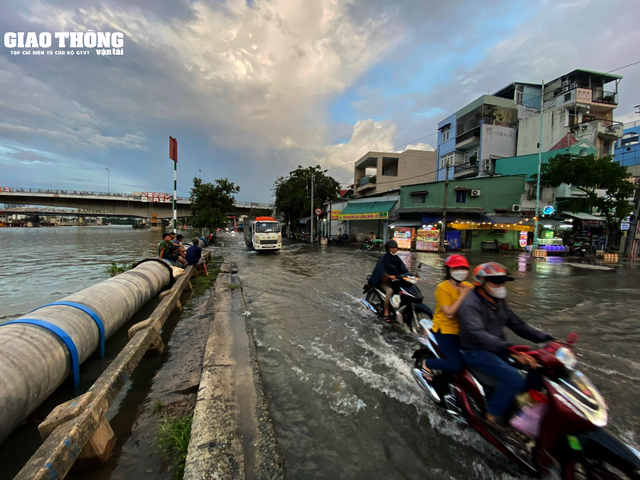 TP. HCM: Đường thành sông, người dân bì bõm lội nước về nhà - Ảnh 1.