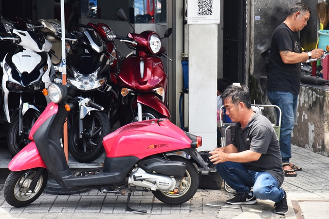 Nhân viên cửa hàng xe máy cũ tại TP. HCM vệ sinh xe trước khi bán cho khách hàng.  9 bộ phận cần kiểm tra kỹ khi mua xe máy cũ