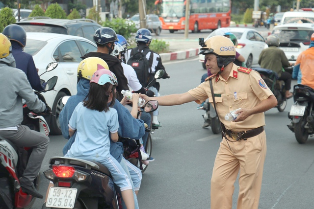 TP. HCM: CSGT tặng nước suối, khăn lạnh đảm bảo ATGT cho người dân về quê nghỉ tết Dương lịch- Ảnh 2.