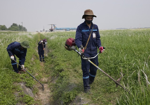 Chùm ảnh: Người lao động làm việc trên đường băng sân bay với nền nhiệt hơn 60 độ C   - Ảnh 5.