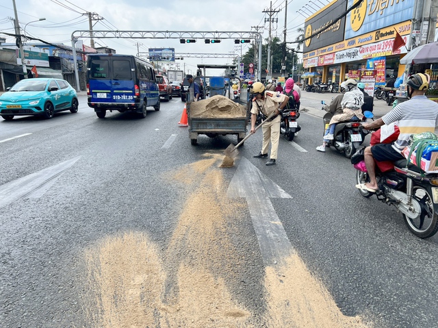 TP. HCM: CSGT dọn vết dầu loang đổ xuống đường khiến nhiều người bị té ngã- Ảnh 1.