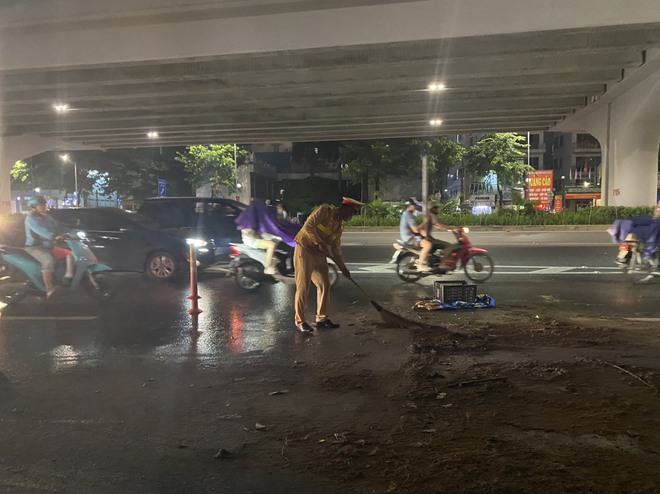 Video CSGT Hà Nội kịp thời dọn vết dầu loang dài 100m trên đường Phạm Văn Đồng - Ảnh 2.