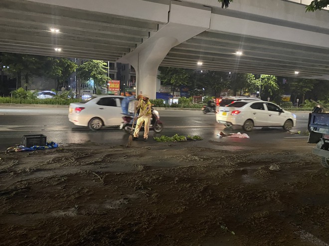 Video CSGT Hà Nội kịp thời dọn vết dầu loang dài 100m trên đường Phạm Văn Đồng - Ảnh 1.